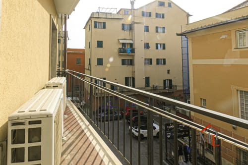 Vista dal balcone dell'appartamento di Genova con edifici gialli, parcheggio in strada e skyline cittadino presso ML White House Ulivo House