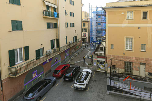 Vista della strada di Genova dal balcone dell'appartamento Ulivo House con auto parcheggiate e edifici storici nel centro città