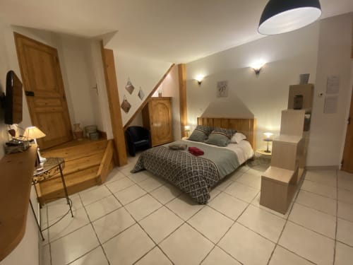 Chambre spacieuse au B&B Le Cocon De Curson à Chanos-Curson avec lit en bois, carrelage beige et éclairage moderne