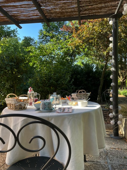 Table de petit-déjeuner en plein air au B&B Le Cocon De Curson à Chanos-Curson, pergola ombragée avec vue sur le jardin