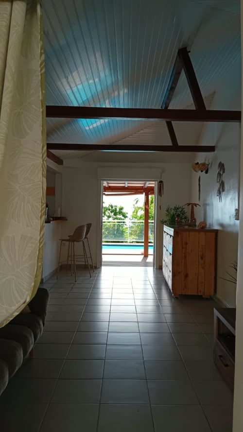 Couloir d'une villa moderne aux poutres apparentes, menant à la piscine et vue sur la mer à Bouillante, Guadeloupe