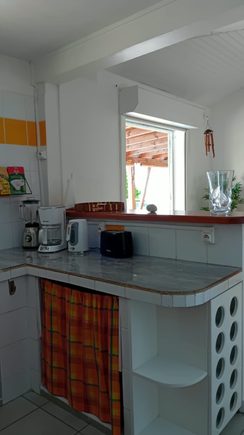 Cuisine moderne de la Villa Ti Soley Mafanga à Bouillante avec plan de travail inoxydable, électroménager et vue mer