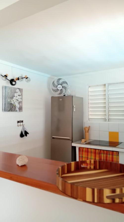 Cuisine moderne à la Villa Ti Soley Mafanga, Bouillante, avec réfrigérateur inox, volets blancs et boiseries