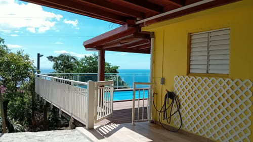 Villa jaune avec balustrade blanche, terrasse vue mer et piscine surplombant les eaux des Caraïbes à Bouillante, Guadeloupe