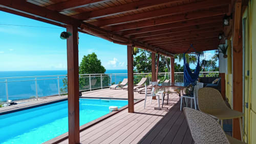 Terrasse de la Villa Ti Soley Mafanga avec piscine privée, vue sur mer, transats et océan Caraïbe à Bouillante, Guadeloupe