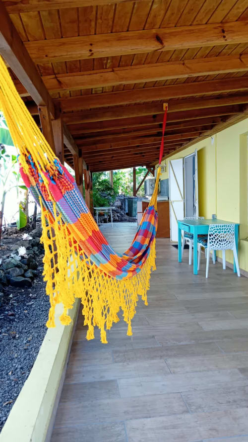Hamacs colorés sur la terrasse couverte de la Villa Ti Soley Mafanga à Bouillante, avec table de salle à manger turquoise