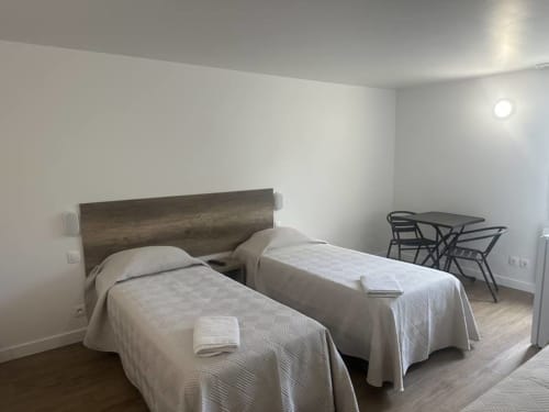 Chambre twin à l'Hôtel Motelia, Moissy-Cramayel avec deux lits, tête de lit en bois et espace de travail