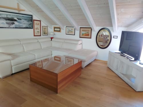 Soggiorno moderno del B&B di Oristano con divano crema, tavolino in legno, TV e quadri incorniciati sotto le travi a vista
