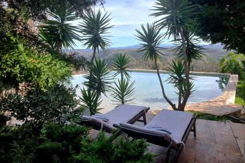 Duas espreguiçadeiras com vista para um lago tranquilo no hotel rural SELÃO DA EIRA em São Teotónio, Alentejo, Portugal