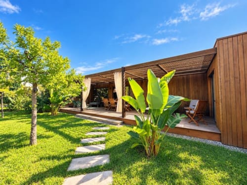 Villa moderne en bois aux Villas d'A Storia à San Gavino di Carbini avec terrasse couverte, plantes tropicales et jardin soigné