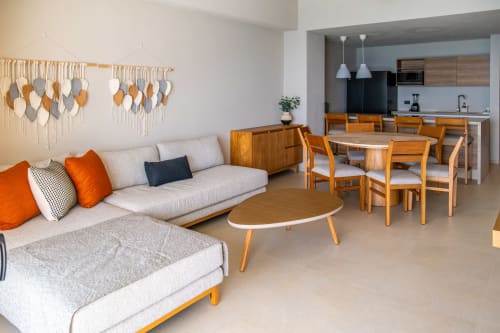 Sala de estar moderna y abierta en Condominio Marlica Manzanillo con sofá beige, muebles de madera y cocina