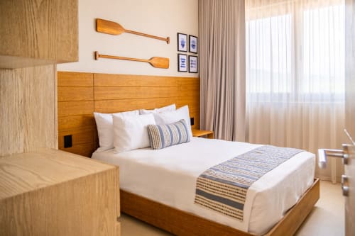 Habitación de huéspedes de Condominio Marlica en Manzanillo con cama de madera, ropa blanca y decoración náutica