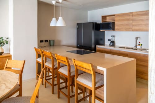 Cocina moderna en Condominio Marlica, Manzanillo, con mueblería de madera, isla con asientos y electrodomésticos negros