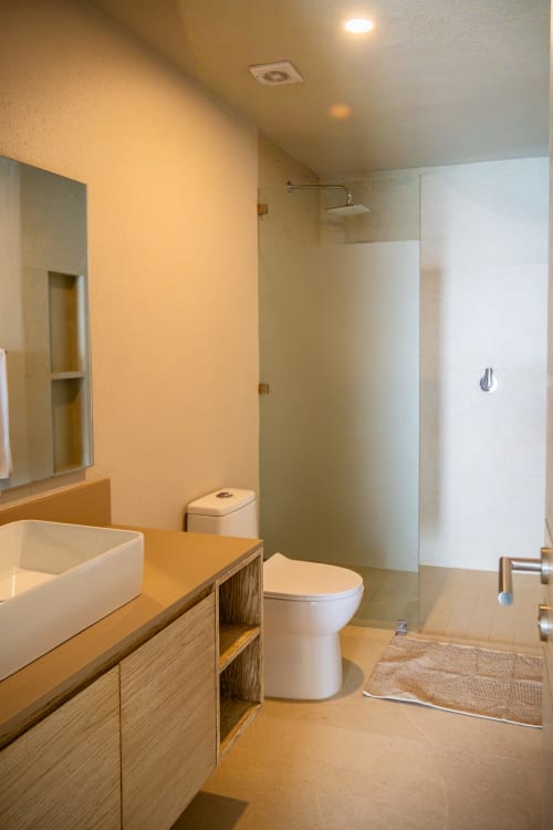 Baño moderno en Condominio Marlica, Manzanillo: mueble de madera, lavamanos blanco, inodoro y ducha con cristal