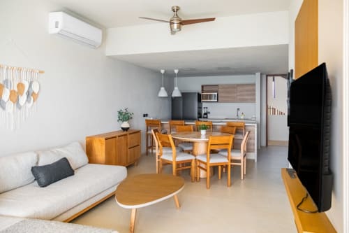 Sala de estar moderna de planta abierta en Condominio Marlica, Manzanillo, con comedor, sofá, cocina y muebles de madera