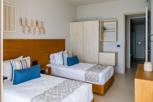 Habitación doble en Condominio Marlica, Manzanillo con cabeceros de madera, detalles azules y mobiliario moderno