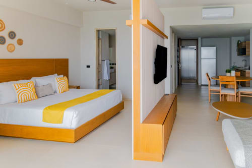 Estudio moderno en Condominio Marlica, Manzanillo, con cama de madera, acentos amarillos, plano abierto y cocina integrada