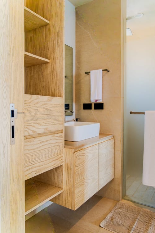 Baño moderno en Condominio Marlica con tocador de madera, lavabo blanco de recipiente y estantes abiertos en Manzanillo