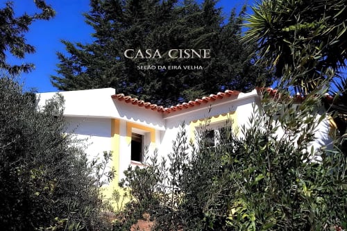 Casa Cisne, casa de campo rural com paredes brancas e telhado de barro, cercada por jardins mediterrânicos no Alentejo, Portugal
