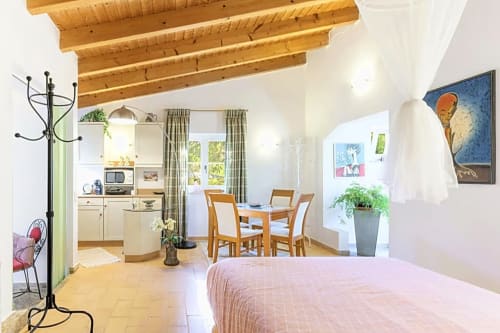 Aconchegante quarto Casa Cisne no hotel rural SELÃO DA EIRA no Alentejo, Portugal, com vigas de madeira, kitchenete, área de refeições e