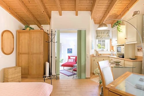 Quarto Casa Cisne no hotel rural SELÃO DA EIRA no Alentejo, Portugal, com vigas de madeira, kitchenette e vista para o jardim
