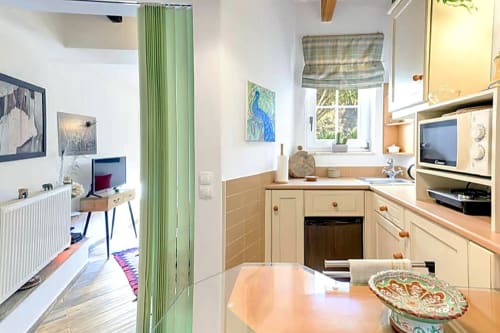 Cozinha compacta moderna em Casa Cisne no agroturismo Selão da Eira no Alentejo, Portugal, com armários creme e toques de verde