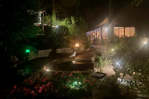 Vista noturna do jardim Casa Cisne com lago iluminado, plantas floridas e villa acesa no hotel rural SELÃO DA EIRA, Alentejo