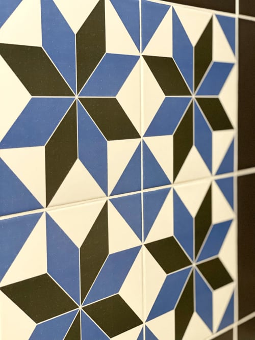 Carrelage géométrique aux losanges bleus, noirs et crème dans une chambre de l'hôtel Pensión Alicante San Nicolás