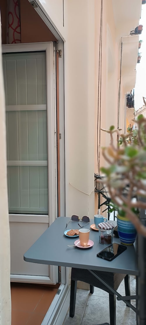 Tavolino di balcone alla Pensión Alicante San Nicolás con caffè, pasticceria e succulente con vista sulla città