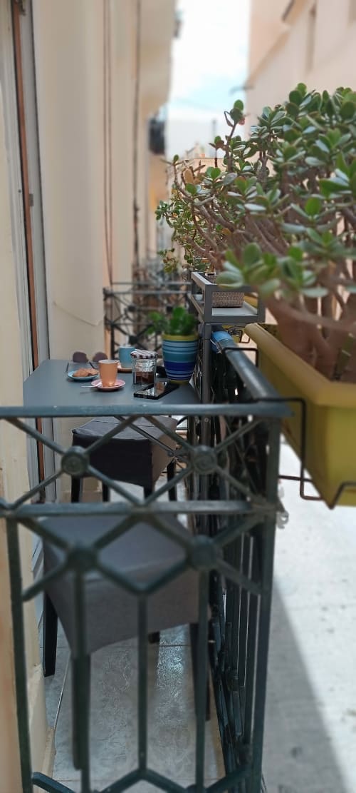 Accogliente balcone della Pensión Alicante San Nicolás con tavolino, piante grasse in vaso e vista sulla città di Alicante