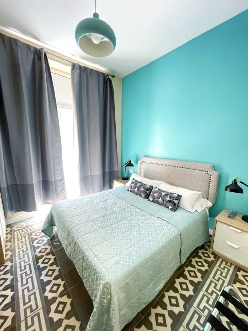 Camera da letto turchese luminosa presso Pensión Alicante San Nicolás con letto queen-size, tende grigie, lampada sospesa e geometrica