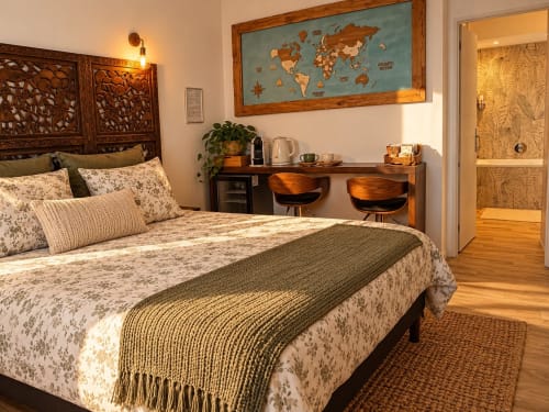 Chambre cosy à la Maison D'hôtes Coeur D'hérault avec parure florale, bureau en bois, carte du monde et équipements modernes