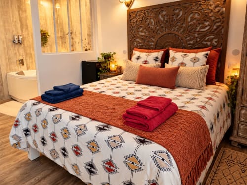 Chambre Montpellier à la Maison D'hôtes Cœur D'hérault à Péret avec tête de lit en bois ouvragé, literie patternnée