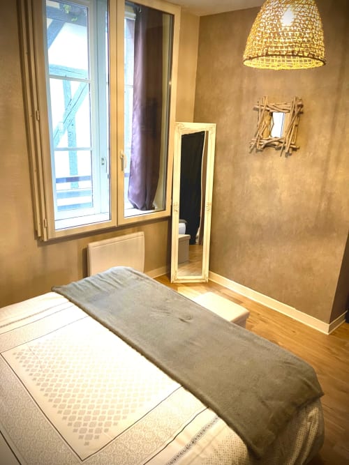 Chambre confortable au Paillot de Montabert, Troyes avec lit, miroir, luminaire suspendu tressé et vue sur la ville