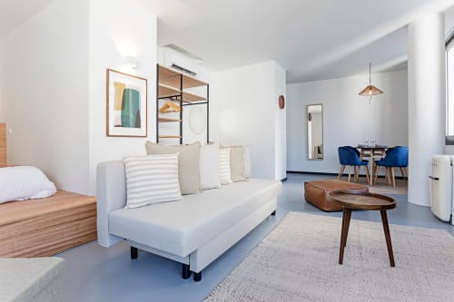 Modern studio apartment at Benefit Collection Porto hotel with white sofa, wooden bed, dining area, and garden view