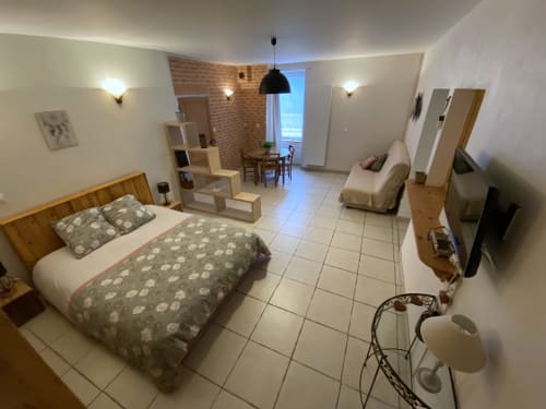 Chambre du gîte Le Cocon à Chanos-Curson avec lit queen-size, salon, kitchenette et équipements modernes