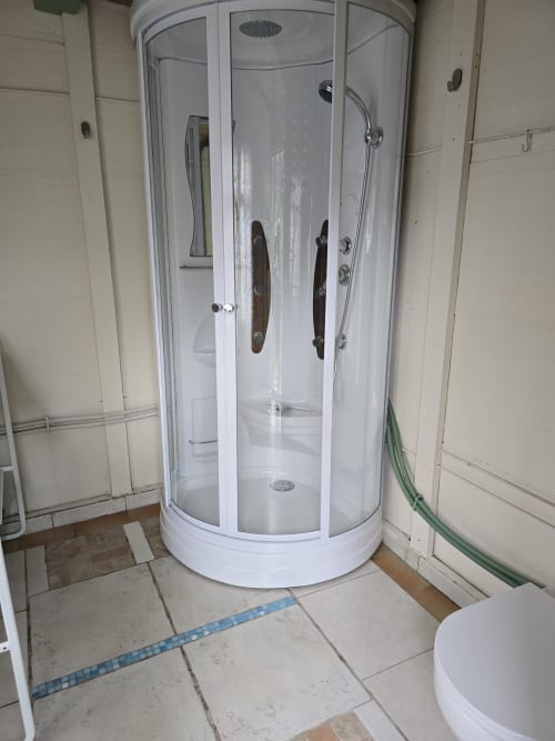 Cabine de douche cylindrique blanche moderne dans la salle de bain d'un cottage du Domaine Trianon, Villandry