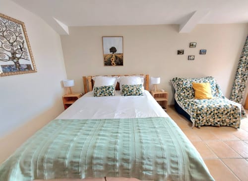 Bright bedroom at Les Gites de Campardon cottage in Monties with double bed and single bed, wooden furniture and garden views