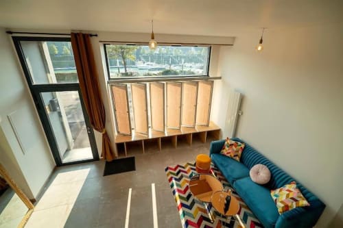 Loft contemporain avec vue sur mer, canapé bleu, rangements en bois et ambiance maritime aux Gîtes Saint-Valery-En-Caux