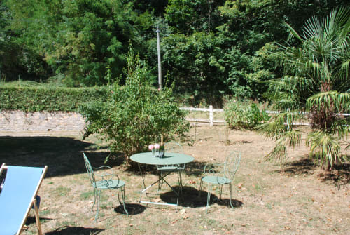 Coin de détente au Château de Vaux Morvan avec mobilier en fer forgé et palmiers