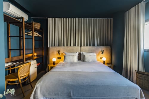 Quarto de estúdio moderno no hotel Porto com cama queen, iluminação de destaque amarela, espaço de trabalho, beliches e janelas do chão ao teto