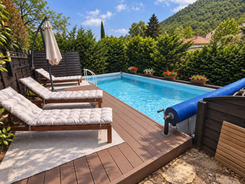 Private pool deck with loungers, umbrella, and mountain views at Mes Maisons gîte in South France
