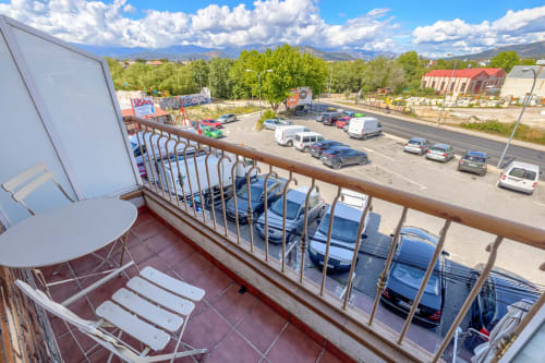 Vista desde el balcón del Hostal El Molino con estacionamiento y montañas, Collado Villalba