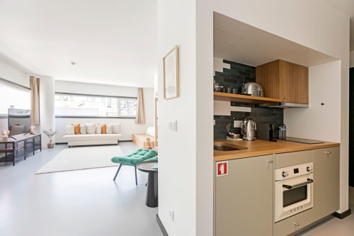 Studio superior com kitchenette de armários em madeira e área de estar no hotel Benefit Collection Porto