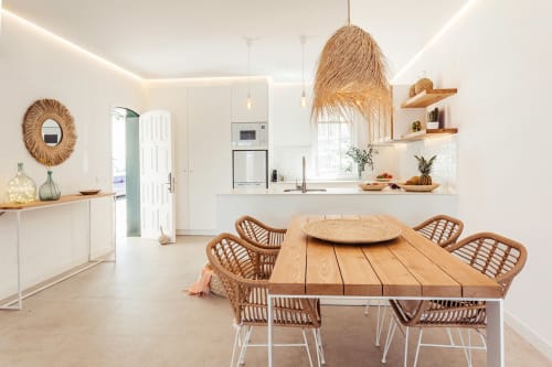 Moderna cocina y comedor en Las Golondrinas Apartamentos, Cap d'Artrutx, con mesa de madera y sillas de ratán