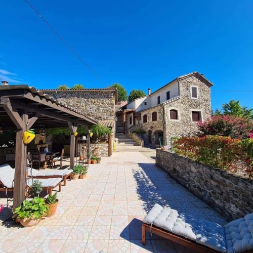 Rustic stone cottages with courtyard, terrace seating, and gardens in Gagnières, South of France