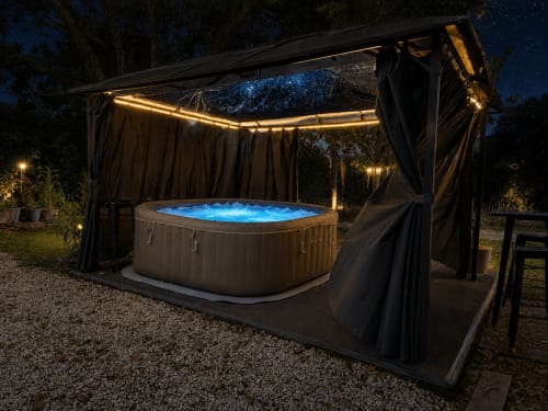 Jacuzzi extérieur illuminé sous pergola, ciel étoilé à Domaine Valenquercy, Le Vignon-en-Quercy