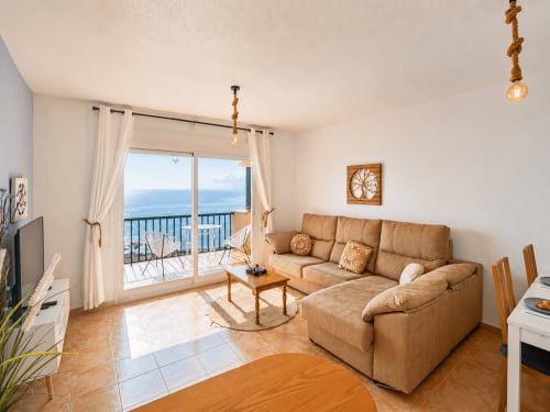 Beachfront apartment living room with tan sofa, sea views from balcony, modern furnishings at El Calón Playa