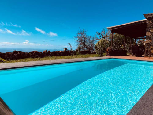 Piscina privada de aguas cristalinas con vistas al océano en Villa El Topo, La Palma, con terraza y vistas a las montañas