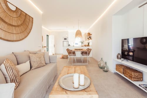 Elegante sala de estar moderna en Las Golondrinas con sofá beige, detalles de madera, comedor y vistas al mar en Cap d'Artrutx